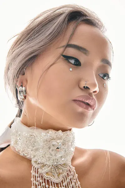 Primer plano de hermosa mujer asiática con elegante maquillaje inclinación cabeza a lado y mirando hacia abajo - foto de stock