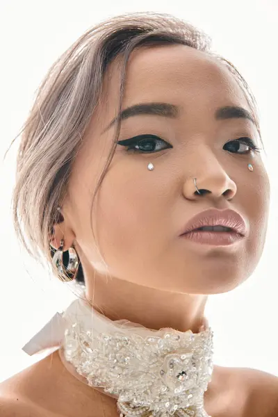 Cerca hasta seguro asiático mujer en su 20s mirando a cámara contra blanco fondo - foto de stock
