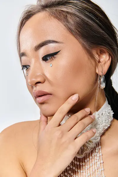 Close up com perfil mulher atraente com maquiagem graça e colar delicado posando com a mão — Fotografia de Stock