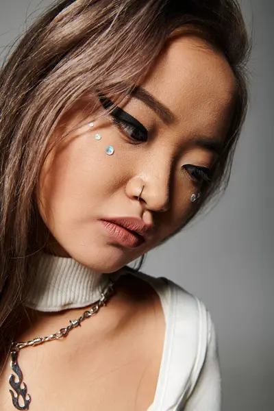 Nahaufnahme von schönen asiatischen Mädchen in ihren Zwanzigern mit schwerem Make-up lehnen Kopf und Blick nach unten — Stockfoto