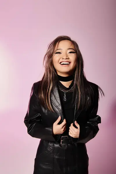 Smiling asian woman in black leather outfit with heavy makeup against lilac background — Stock Photo
