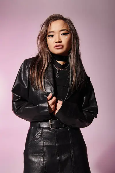 Atraente asiático jovem mulher no preto couro roupa com pesado maquiagem contra lilás fundo — Fotografia de Stock