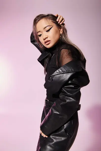 Pretty young woman in black leather outfit posing to sideways against lilac background — Stock Photo