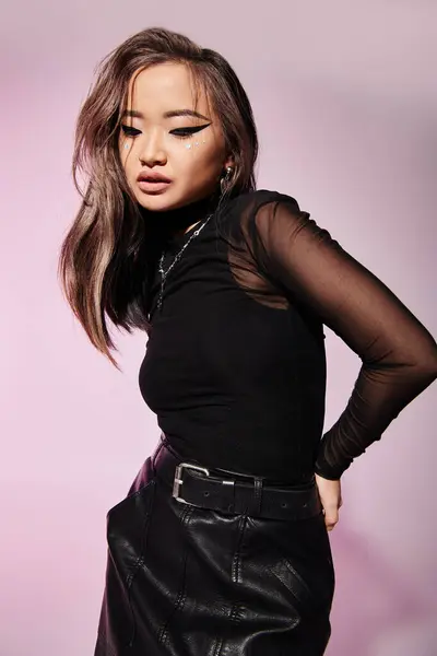 Charming asian woman with brown hair and heavy makeup looking to down on lilac background — Stock Photo