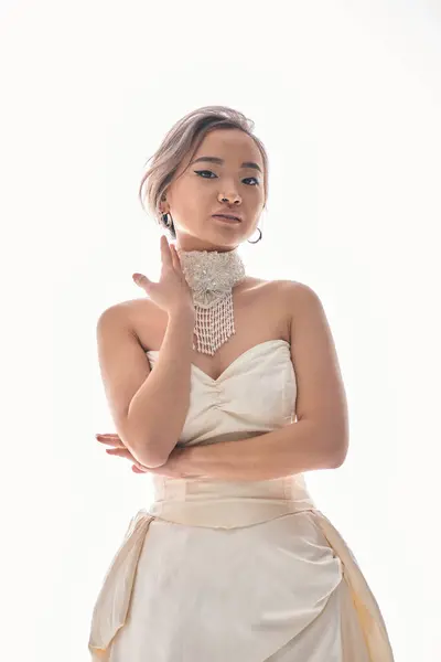 Charming asian young woman with brown hair in white elegant dress posing with hands — Stock Photo