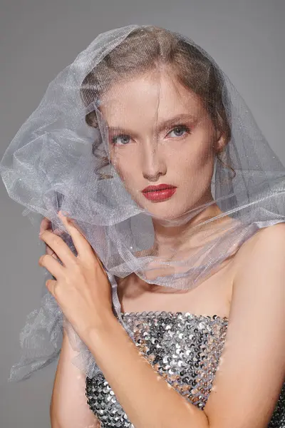 Una joven emana belleza clásica, posando en un estudio con un velo elegante sobre su cabeza. - foto de stock