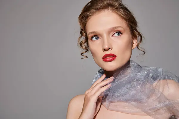 Une jeune femme respire la beauté classique en posant dans un studio, portant un voile et un rouge à lèvres rouge frappant. — Photo de stock