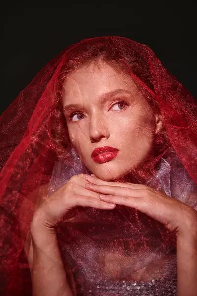Eine junge Frau strahlt klassische Schönheit mit Schleier und fettem roten Lippenstift in einem Studio vor schwarzem Hintergrund aus. — Stockfoto