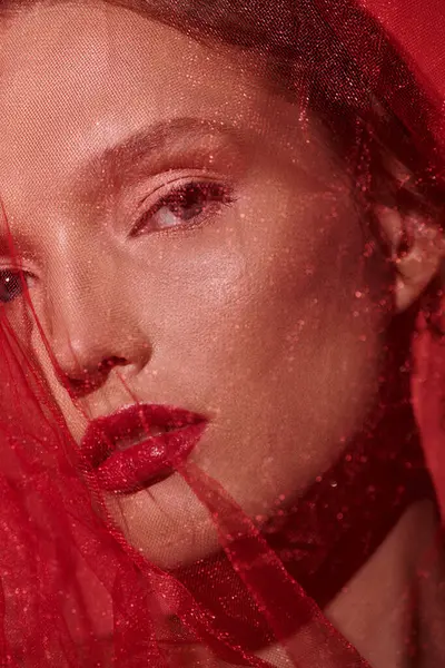 A young woman with vibrant red hair and matching lipstick exudes timeless elegance in a studio setting against a black background. — Stock Photo