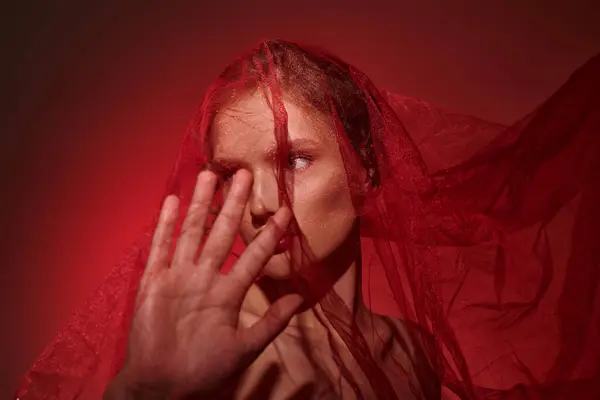 Eine junge Frau von klassischer Schönheit, die ihr Gesicht in einem Studio vor schwarzem Hintergrund mit den Händen bedeckt. — Stockfoto