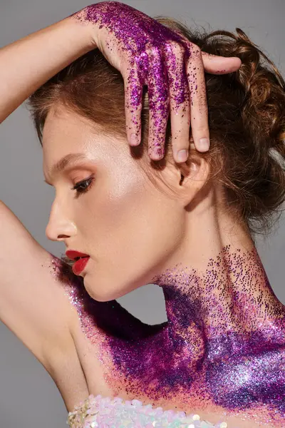 Eine junge Frau mit klassischer Schönheit posiert in einem Atelier, ihr Körper ist mit leuchtend lila Farbe verziert. — Stockfoto