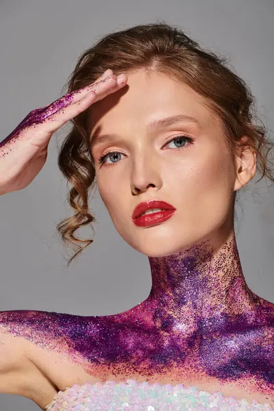 Une jeune femme à la beauté classique pose dans un studio recouvert de peinture violette et rose, exsudant une élégance éthérée. — Photo de stock