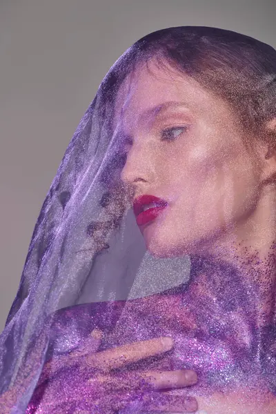 Una joven exuda belleza clásica en un ambiente de estudio, llevando un delicado velo gris en la cabeza. - foto de stock