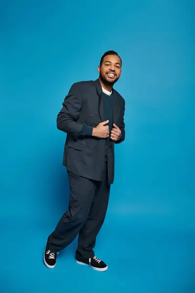 Красивий афроамериканський молодий чоловік в темно-синьому вбранні позує на яскравому фоні — стокове фото