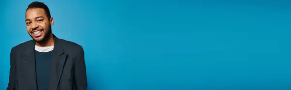 Банер афроамериканського молодого хлопця в темно-синьому вбранні, посміхаючись камері на яскравому фоні — стокове фото