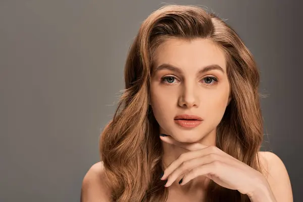 Una joven y hermosa mujer con el pelo ondulado y ondulado posando para un retrato. - foto de stock