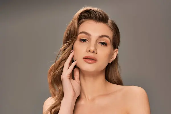A young woman with long wavy hair strikes a confident pose — Stock Photo