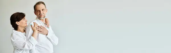Portrait of middle aged stylish couple hugging and holding hands on grey background, banner — Stock Photo