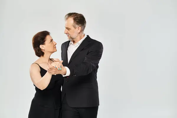 Ballroom dança casal de meia idade em uma pose de dança e sorrindo isolado em fundo cinza — Fotografia de Stock