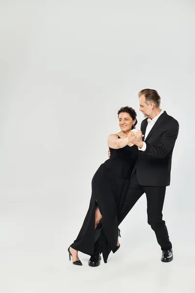 Prise de vue pleine longueur d'un beau couple mature dans une pose de danse tango isolé sur fond gris — Photo de stock