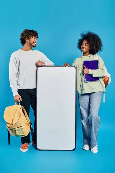 A man and a woman stand by a mockup, Cultural diversity — Stock Photo