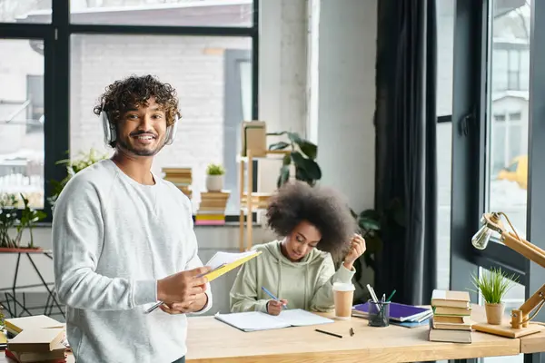 A man stands at a desk in front of a black woman in modern office space — Stock Photo