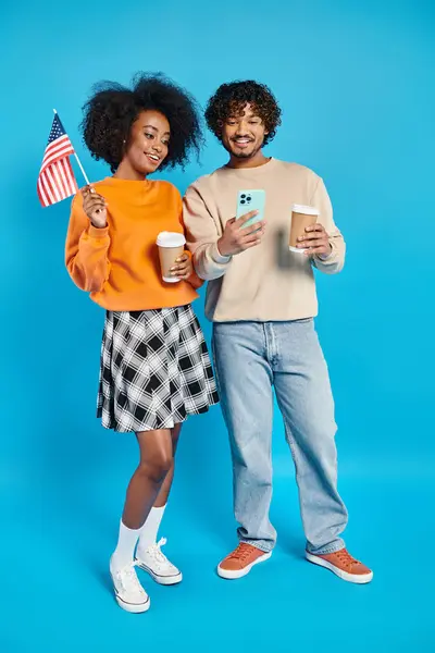 Um homem e uma mulher, estudantes inter-raciais, estão ao lado um do outro em trajes casuais contra um pano de fundo azul. — Fotografia de Stock