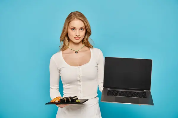 Blonde Frau hält Teller mit asiatischem Essen vor Laptop-Bildschirm. — Stockfoto