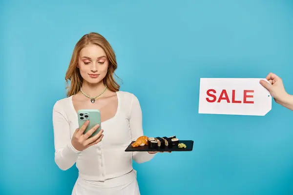 Una donna elegante con i capelli biondi che controlla il suo telefono accanto a un segno di vendita per il cibo asiatico scontato. — Foto stock