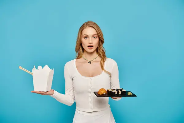 Eine atemberaubende blonde Frau in einem weißen Kleid hält ein Tablett mit köstlichen asiatischen Gerichten in der Hand. — Stockfoto