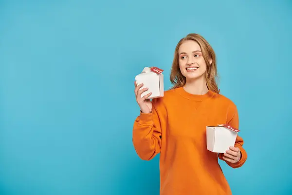 A girl happily holds two boxes of Asian food in her hands with sales tag. — Stock Photo