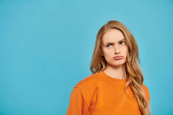 Uma mulher deslumbrante com cabelo loiro posando no fundo azul. — Fotografia de Stock