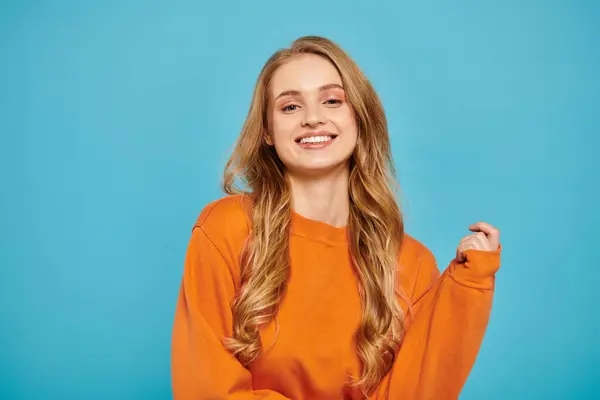 A stylish blonde woman striking a pose while on bright backdrop. — Stock Photo