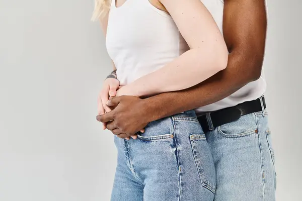 Un jeune couple multiculturel se tient côte à côte dans un studio, leur présence exsudant unité et connexion. — Photo de stock