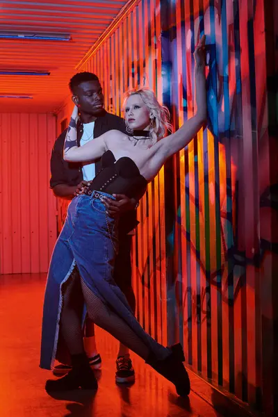 Une femme blonde et un Afro-Américain dansant gracieusement dans une pièce, se déplaçant en parfaite synchronisation les uns avec les autres. — Photo de stock
