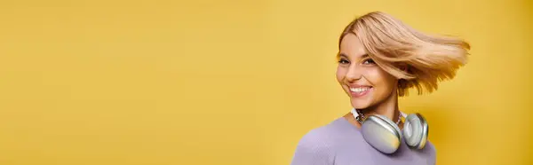 Mulher alegre chique com cabelo loiro curto e fones de ouvido desfrutando de música no fundo amarelo, banner — Fotografia de Stock
