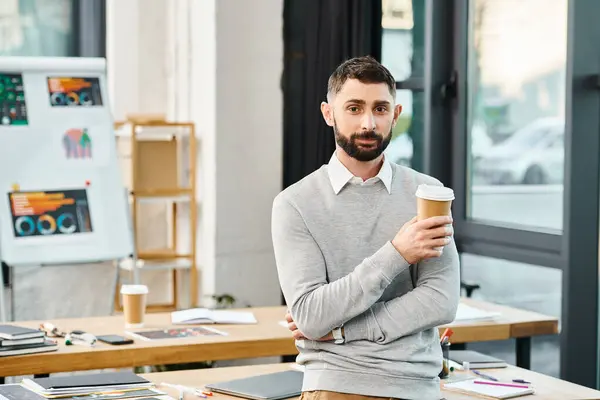 Um homem de negócios se entrega a uma xícara de café fumegante, encontrando inspiração antes de mergulhar de volta em projetos corporativos. — Fotografia de Stock