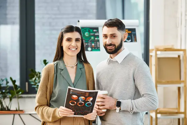 A man and a woman in a business setting, standing side by side, portraying collaboration and teamwork in an office. — Stock Photo