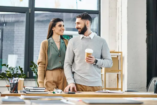 Un uomo e una donna si impegnano in una discussione produttiva in uno spazio ufficio moderno, mettendo in evidenza il lavoro di squadra aziendale e la comunicazione.. — Foto stock