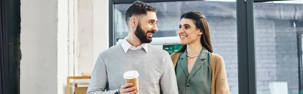 A man and a woman standing together, embodying teamwork and collaboration in a corporate office setting. — Stock Photo