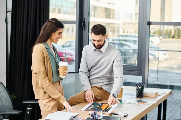 A man and woman engage in deep discussion while sitting at a table in a modern office, immersed in corporate culture. — Stock Photo