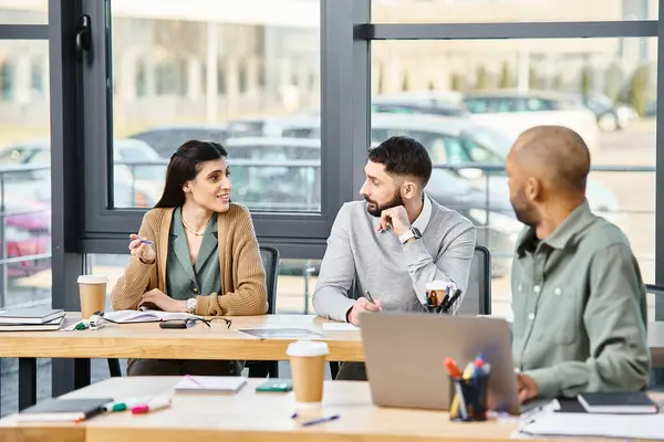 A group of professionals discussing a project, seated around a wooden table in a corporate office setting. — Stock Photo