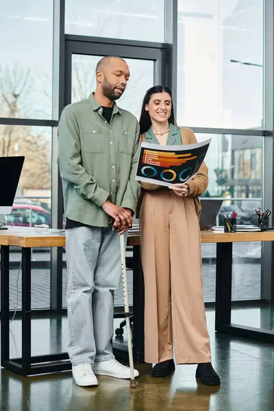 Инвалиды мужчина и женщина стоят вместе в бизнес-офисе, обсуждая проект как часть корпоративной культуры. — стоковое фото