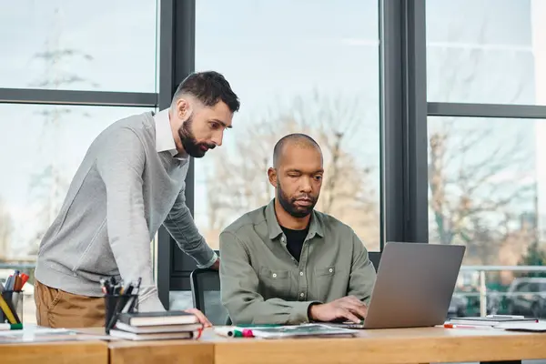 Dois homens envolvidos em trabalho colaborativo em um laptop em um ambiente de escritório profissional, focado e produtivo, diversidade e inclusão — Fotografia de Stock