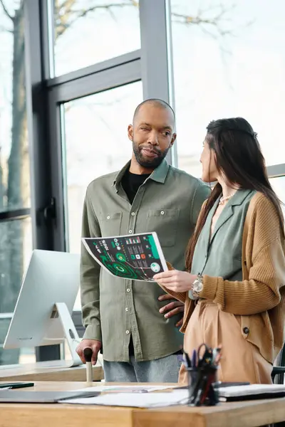 A man with myasthenia gravis and a woman collaborating on a map inside an office, engrossed in their work as they strategize and plan. — Stock Photo
