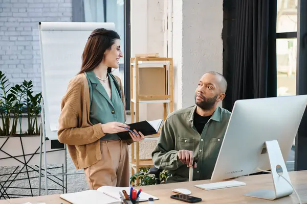 A disabled man with myasthenia gravis and a woman are brainstorming in front of a computer in a modern office setting. — Stock Photo