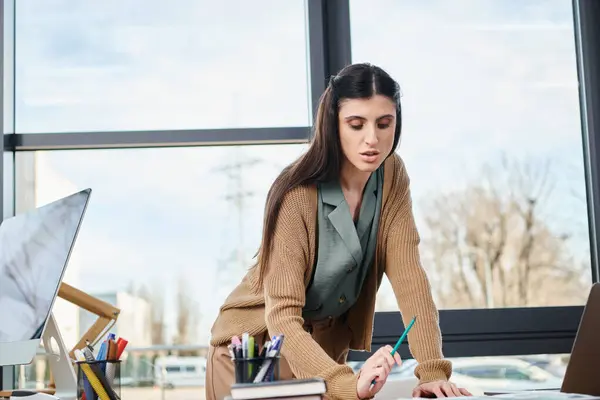 Uma mulher em ambiente corporativo, focada na tarefa de escrever na mesa. — Fotografia de Stock