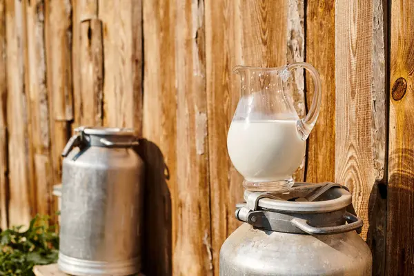 Objektfoto einer metallenen Urne und einem Glas frischer Milch, die außerhalb des nahe gelegenen Dorfhauses auf einem modernen Bauernhof platziert wurden — Stockfoto