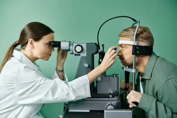 El médico examina los ojos de los hombres a través de un microscopio en un consultorio médico para la corrección de la visión láser. - foto de stock