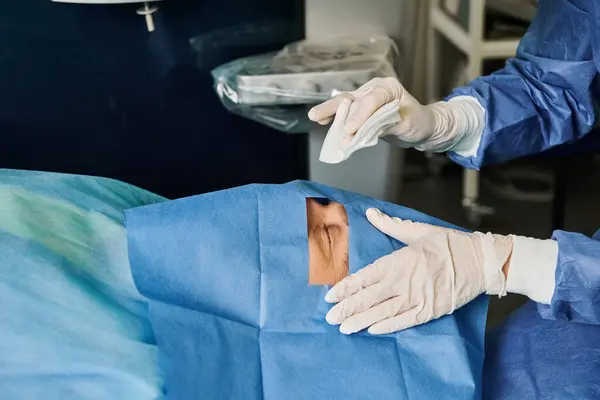 Cirujano en guantes realizando corrección de visión láser en un paciente. - foto de stock